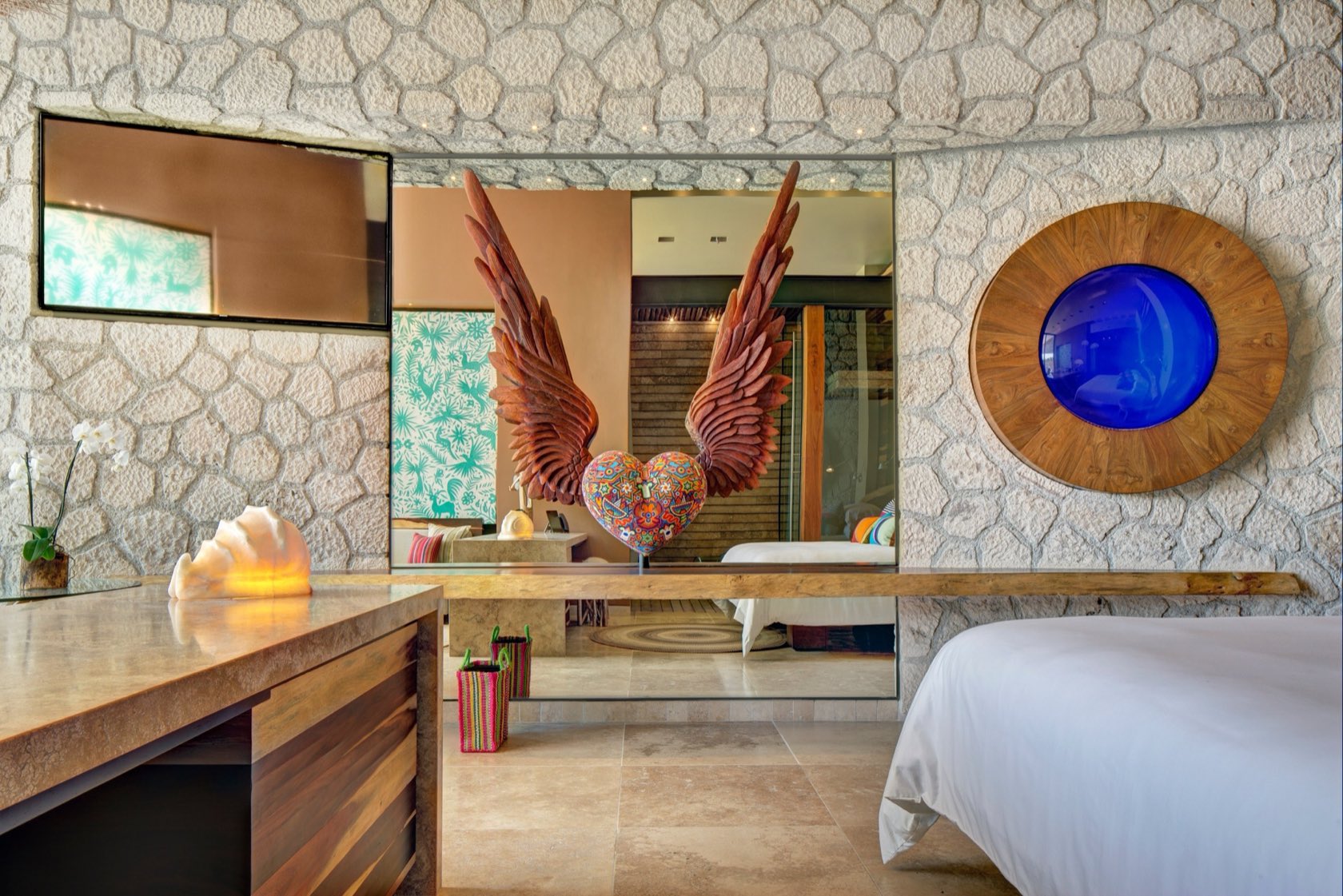 Suite interior at La Casa de la Playa featuring the signature carved winged-heart art piece