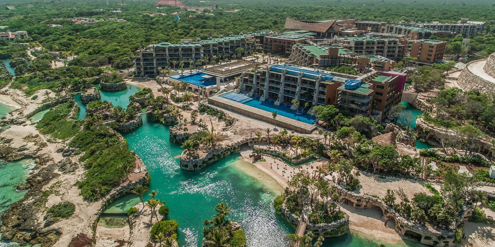 Aerial of Hotel Xcaret Mexico showing the signature turquoise rivers winding past the resort